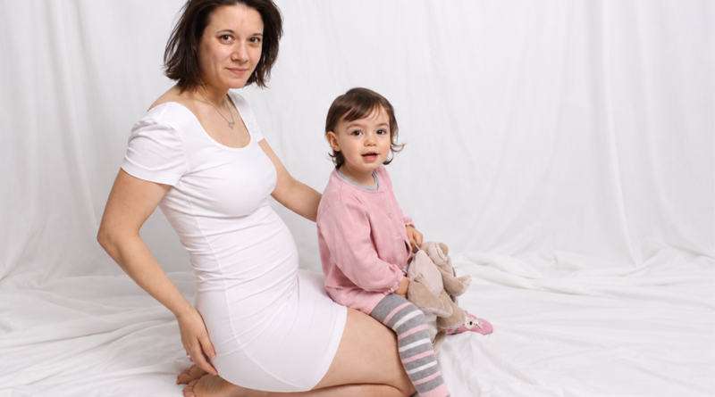 Portrait en blanc d’une maman enceinte et sa fille