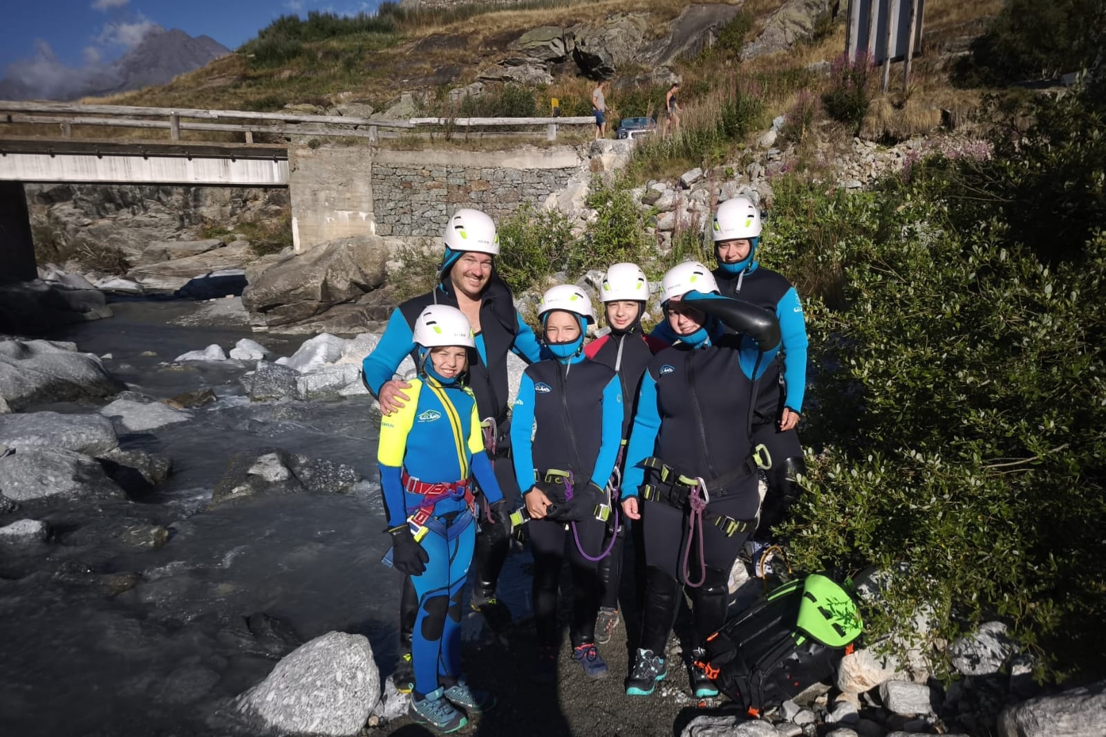 photo de famille en tenue de canyoning, au bord d'un cour d'eau pour illustrer notre famille recomposée