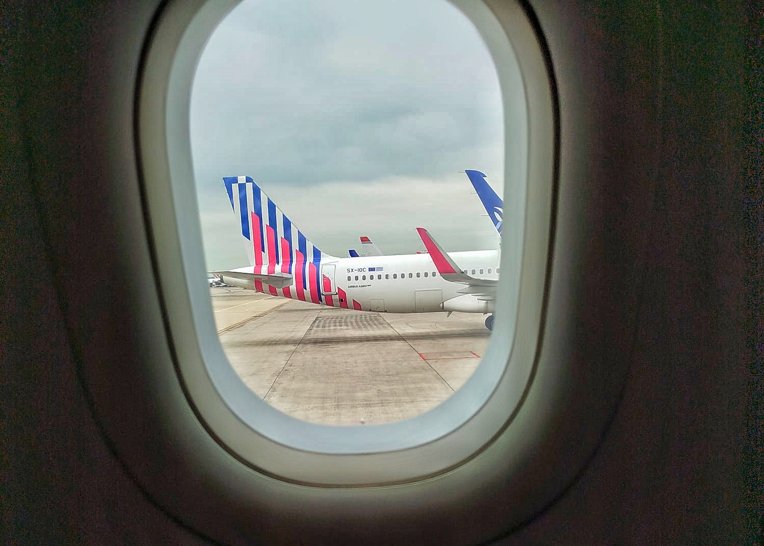 vue depuis le hublot d'un avion d'un autre avion posé sur le tarmac de l'aéroport