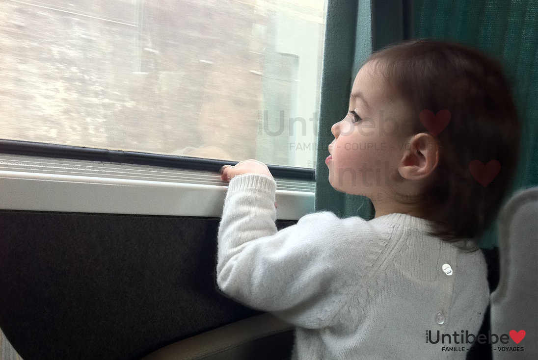 un enfant regarde par la fenêtre du train