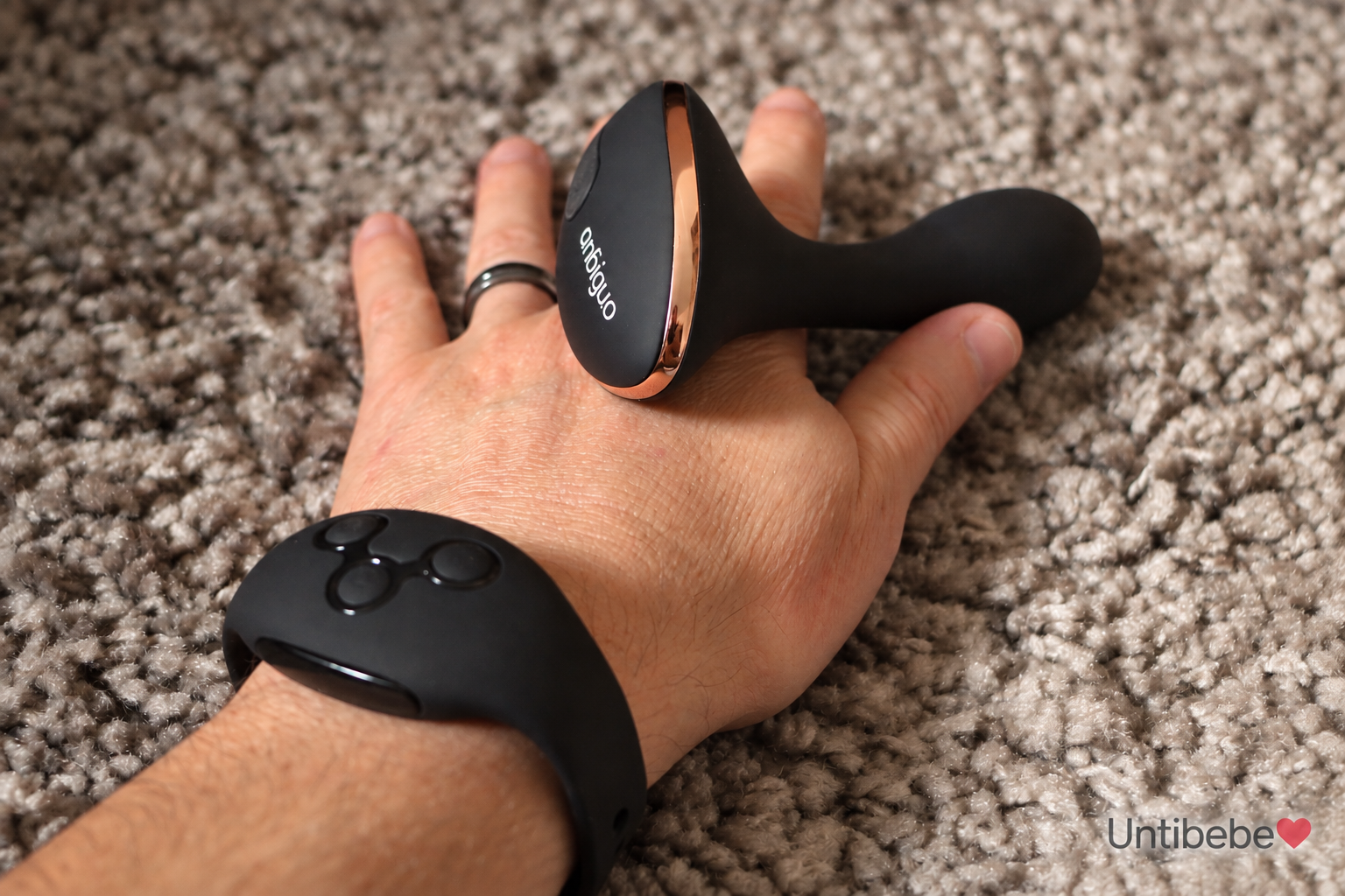 jouet anal dans la main d'un homme équipé d'une montre connectée au jouet